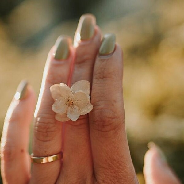 Une bague composée de fleurs vivantes en résine