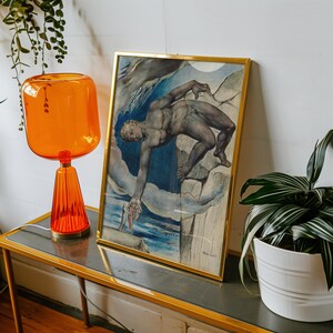 May include: A framed print of a watercolor painting depicting a nude male figure reaching out with his right hand. The figure is standing on a rocky outcrop with a blue and white cloudy sky in the background. The print is framed in a gold frame.