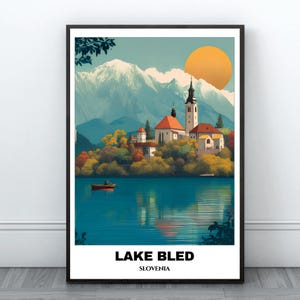 Può includere: Una stampa artistica incorniciata del lago di Bled, Slovenia. L'immagine presenta un lago sereno con una piccola barca, una chiesa e montagne sullo sfondo. Il cielo è azzurro con un grande sole arancione. Il testo "LAKE BLED SLOVENIA" è in basso.