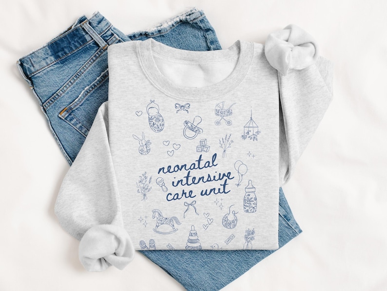 K&ouml;nnte beinhalten: Ein graues Sweatshirt mit einem blauen Design aus babybezogenen Symbolen und dem Text "neonatal intensive care unit".