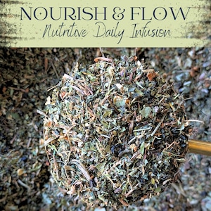 May include: Close-up of a scoop filled with a blend of dried herbs and leaves. The text "NOURISH & FLOW Nutritive Daily Infusion" is at the top. The herbs are a mix of green, brown, and tan, suggesting a natural product.