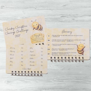 May include: A spiral-bound Sunday Scripture Savings Challenge 2027 tracker with a yellow bee theme. The cover features a bee holding a sign reading Proverbs 16:24. The interior page shows a January calendar with scripture verses and a bee graphic.