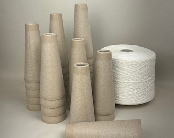 May include: A collection of brown paper cones stacked and arranged on a beige surface, with a spool of white yarn in the background.