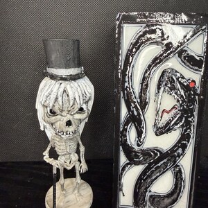 Dapper Skeleton figurine with top hat in crypt
