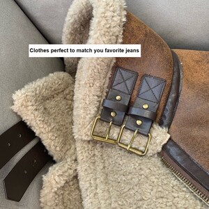 Op de afbeelding: Een bruin nep leren jack met een bontvoering. Het jack heeft een ritssluiting en twee bruine leren banden met gouden gespen.