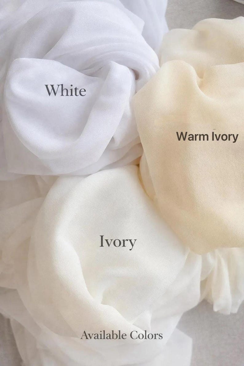 May include: Three swatches of sheer fabric in different shades labelled White, Warm Ivory, and Ivory. The text Available Colours is printed at the bottom. The fabric has a soft, draped texture with visible folds and light-filtering properties.