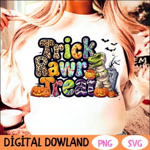 Puede incluir: Una camiseta blanca de manga larga con el texto "Trick Rawr Treat" en letras de colores. El texto está rodeado de imágenes de calabazas, un dinosaurio sosteniendo un cubo y un patrón tie-dye.