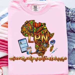 May include: Pink t-shirt with a graphic featuring an African continent outline filled with colorful patterns, the letters "LPN" in gold, and medical tools. The text "#licensedpracticalnurse" is below the graphic.