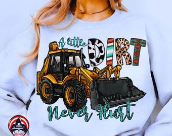 Può includere: Felpa azzurra con grafica di un veicolo da cantiere giallo e la scritta "A little DIRT Never Hurt". La parola "DIRT" è in una miscela di motivi, tra cui stampa di mucca e turchese.