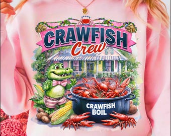 Könnte beinhalten: Rosafarbener Pullover mit einem Comic-Alligator, der eine Fliege trägt und einen Topf mit Krebsen hält. Der Text "Crawfish Crew" befindet sich über dem Alligator und "Crawfish Boil" steht auf dem Topf.