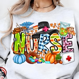 May include: White sweatshirt with a colorful "NURSE" graphic. The design includes a stethoscope, pumpkins, pills, a medical kit, and a pilgrim hat with a cross. The letters are decorated with fall and medical-themed elements.