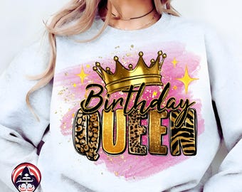 May include: A white sweatshirt with a "Birthday Queen" graphic. The design features a gold crown, the word "Birthday" in black script, and "QUEEN" in gold with animal print accents. Pink and gold accents complete the design.