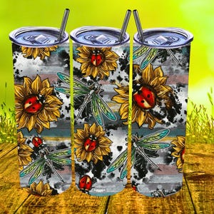 Può includere: Tre bicchieri in acciaio inossidabile con un design in bianco e nero con girasoli, coccinelle e libellule. I bicchieri hanno un aspetto rustico e vintage.