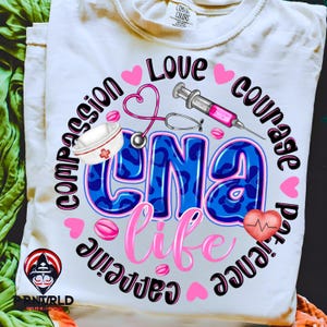 May include: White t-shirt with a colorful graphic design. The design includes the text "CNA Life" in blue with a leopard print pattern, surrounded by hearts, medical symbols, and the words "Love, Compassion, Courage, Patience, Caffeine".