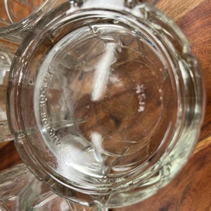Puede incluir: Primer plano de un vaso de vidrio transparente para beber con una superficie texturizada. El vaso est&aacute; vac&iacute;o y parece nuevo.