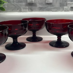 May include: Set of five ruby red glass dessert dishes with a footed base.
