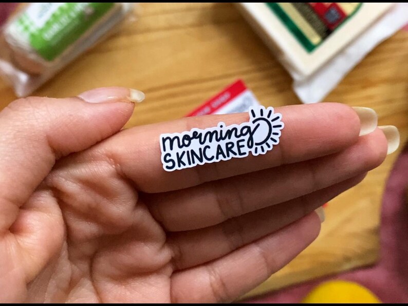 May include: A white sticker with black text that reads "morning skincare" and a sun graphic.