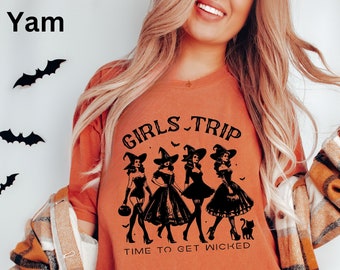 May include: Orange t-shirt with a black graphic of four witches in silhouette with the text "Girls Trip" and "Time to Get Wicked".