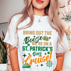 May include: White t-shirt with a green shamrock and the text "Bring out the Booze We're on a St. Patrick's Day Cruise!" with a cruise ship and a steering wheel graphic.