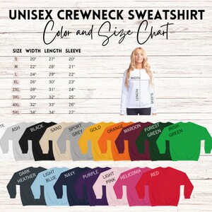 May include: Unisex crewneck sweatshirt size chart with measurements in inches. The chart shows the width, length, and sleeve length for sizes S through 5XL. The chart is displayed on a woodgrain background. The sweatshirt is available in a variety of colors, including white, ash, black, sand, sport grey, gold, orange, maroon, forest green, Irish green, dark heather, light blue, navy, purple, light pink, heliconia, and red.