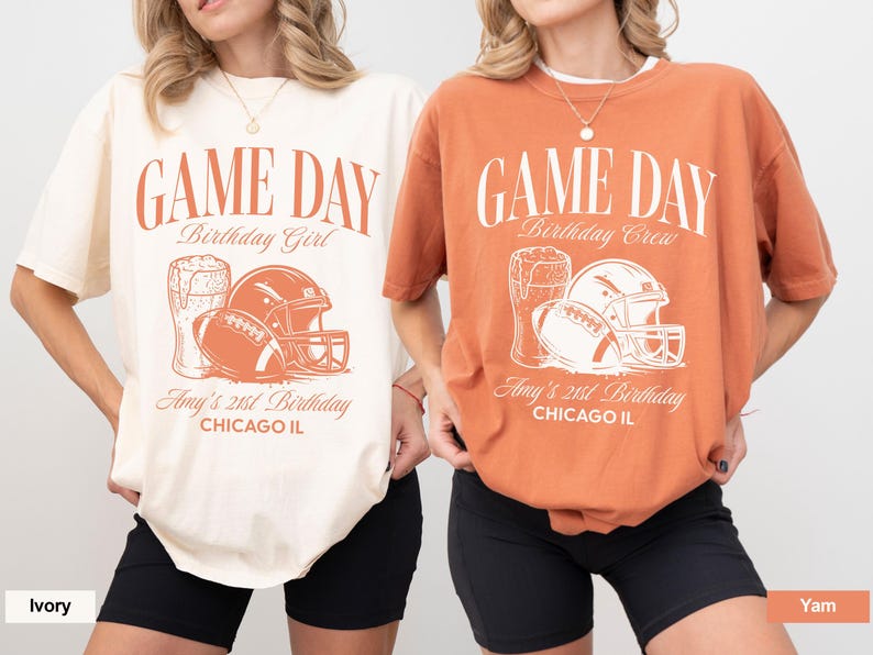 Op de afbeelding: Twee T-shirts, &eacute;&eacute;n ivoorkleurig en &eacute;&eacute;n yam-kleurig, met een voetbalthema. Elk shirt heeft de tekst "GAME DAY" en een afbeelding van een voetbal, helm en bier. De tekst "Birthday Girl" en "Birthday Crew" worden ook weergegeven.