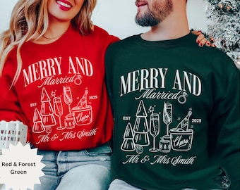 Può includere: Felpe rosse e verde foresta con la scritta "MERRY AND Married" e "Mr & Mrs Smith". Il design include calici di champagne, una bottiglia di champagne in un secchiello del ghiaccio e alberi di Natale. Viene visualizzato anche l'anno "2025".