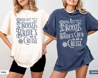 May include: Two t-shirts with a nautical theme. The ivory t-shirt says "Bring out the booze, the bride's on a cruise". The denim t-shirt says "Bring out the booze, this bride's crew is on a cruise".