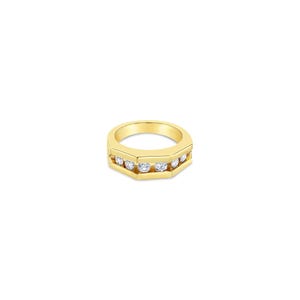 May include: A polished yellow gold band ring featuring a flat, geometric top surface with a horizontal channel setting. Five round, clear, faceted stones are embedded in a row along the center of the band, creating a continuous sparkling line.