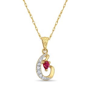 May include: A gold necklace with a pendant shaped like a crescent moon with a red heart in the centre. The moon is accented with small clear stones.