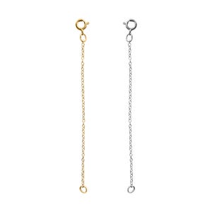 May include: Two extender chains for necklaces, one gold and one silver. Each chain has a lobster clasp at the top and a jump ring at the bottom.