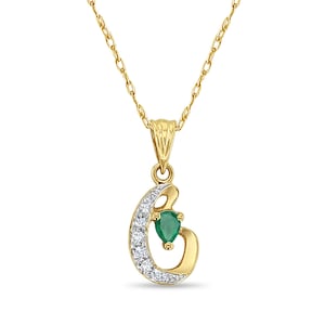 May include: A gold chain necklace with a pendant shaped like the letter 'C' with a green gemstone and small clear stones.