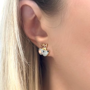 May include: Gold-tone mouse stud earrings with a crown. The mouse is light gray with a pink ear and a white whisker. The crown is gold with a red jewel. The earrings are small, measuring approximately 0.5 inches in height.
