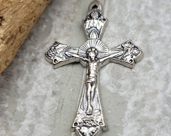 May include: A silver-toned metal crucifix pendant with a detailed design of grapes and leaves. The figure of Jesus Christ is depicted on the cross.