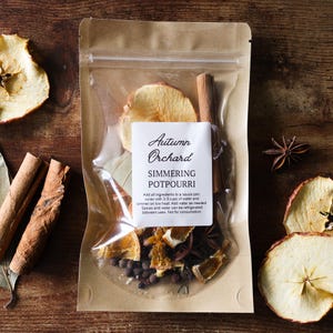May include: A clear plastic pouch with a brown paper backing containing Autumn Orchard simmering potpourri. The label reads: Autumn Orchard, SIMMERING POTPOURRI, Add all ingredients to a sauce pan, cover with 2-3 cups of water and simmer on low heat.