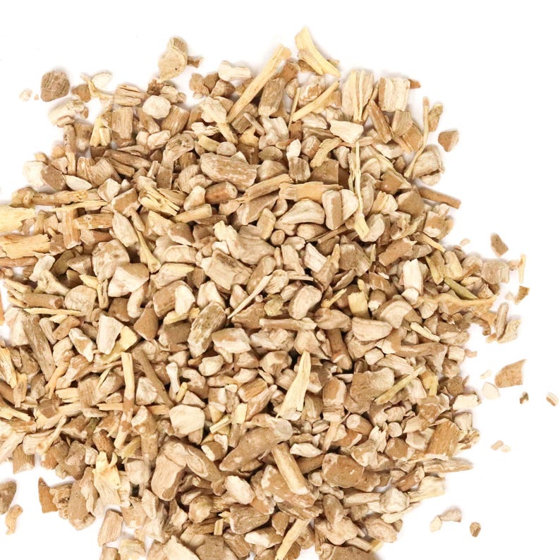 May include: A collection of small, irregularly shaped pieces of dried plant root. The fragments vary in size and texture, displaying a range of light tan, beige, and off-white colors with a fibrous, woody appearance throughout the pile.