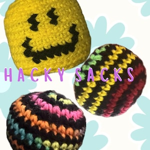 May include: Three colorful hacky sacks. One is yellow with a black smiley face, another is striped with black, red, yellow, and green, and the third is striped with black, pink, orange, and teal. The text "HACKY SACKS" is in the image.