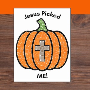 May include: A rectangular print featuring a pumpkin illustration created with orange and green paper mosaic pieces. A beige cross is centered on the pumpkin. The text "Jesus Picked" appears above the pumpkin, and "ME!" is printed below it.