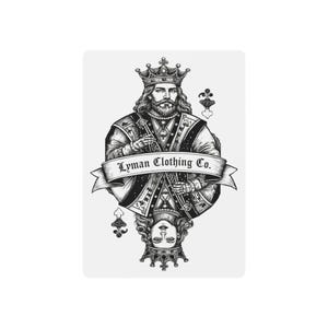 May include: A black and white graphic illustration of a playing card featuring a king and queen in a mirrored design. A central banner across the middle displays the text Lyman Clothing Co. in a serif font, with spade symbols at the corners.