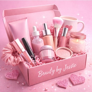 May include: A pink gift box containing beauty products such as makeup, skincare items, and a candle. The box is labelled "Beauty by Jessie." Glitter heart decorations and a mug with a heart design are also visible. The overall theme is soft and feminine.
