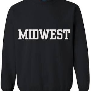May include: Black sweatshirt with the word "MIDWEST" printed in large, white, block letters across the chest. The sweatshirt has a crew neck and long sleeves, suitable for cooler weather.