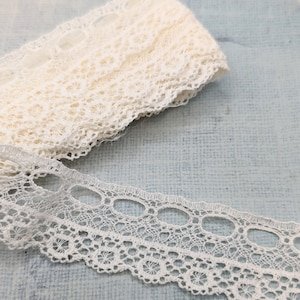 Puede incluir: Borde de encaje blanco con un patrón delicado. El encaje tiene un borde festoneado y es perfecto para agregar un toque de elegancia a cualquier proyecto.