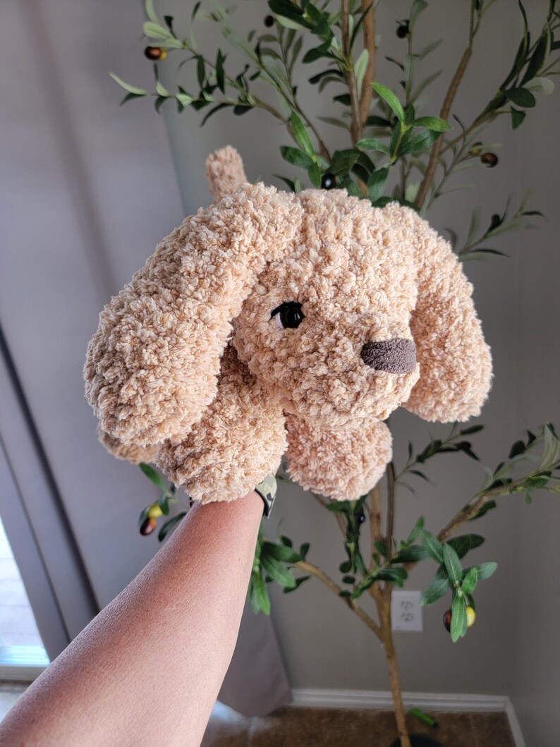 Puede incluir: Un juguete de perro de crochet suave y peludo, de color beige con ojos negros y nariz marr&oacute;n.