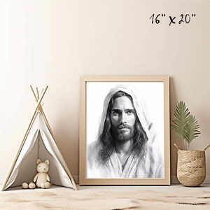 May include: Black and white drawing of Jesus Christ with long hair and beard, wearing a white robe with a hood. The drawing is framed in a light wood frame. The image is 16 inches by 20 inches.