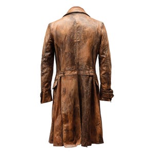 K&ouml;nnte beinhalten: Ein langer, brauner Ledermantel mit Used-Look. Der Mantel hat einen Reverskragen, Kn&ouml;pfe und Taschen. Die R&uuml;ckansicht zeigt einen G&uuml;rtel in der Taille und einen langen, flie&szlig;enden Rock.