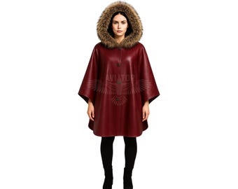 May include: A burgundy leather cape with a fur-trimmed hood. The hooded cape has a button closure and is worn over black pants and boots. The image is set against a white background.