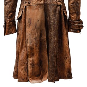 K&ouml;nnte beinhalten: Ein brauner Ledermantel mit einem abgenutzten, strukturierten Aussehen. Der Mantel hat eine lange L&auml;nge, Kn&ouml;pfe und Taschen. Die &Auml;rmel haben gekn&ouml;pfte Manschetten. Der Stil deutet auf eine Vintage- oder Steampunk-&Auml;sthetik hin.