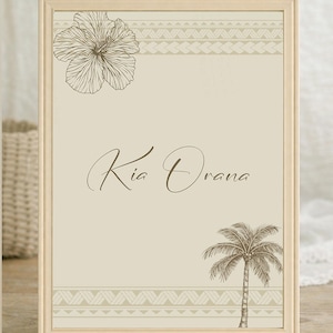 Op de afbeelding: Een ingelijste print met een beige achtergrond, met een hibiscusbloem, palmboom en geometrische patronen in bruin. De tekst "Kia Orana" is geschreven in een scriptlettertype.