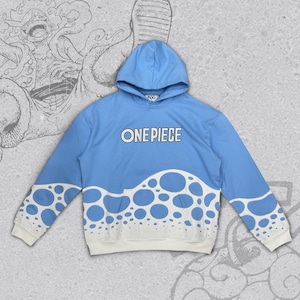 Può includere: Felpa con cappuccio azzurra con la scritta "ONE PIECE" sul petto. La parte inferiore della felpa presenta un design bianco con cerchi blu. Le maniche e il cappuccio sono azzurri. I polsini e l'orlo sono bianchi.