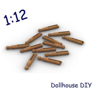 Puede incluir: Un conjunto de pequeñas pinzas de ropa de madera, ideales para proyectos de casas de muñecas. Las pinzas son de color marrón claro y están dispersas sobre una superficie blanca. También se ve el texto "1:12" y "Dollhouse DIY".