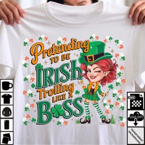 May include: White t-shirt with the text "Pretending to be Irish Trolling Like a Boss" and a cartoon of a winking woman in a green outfit and hat, holding a shamrock. The design includes shamrocks and orange flowers.